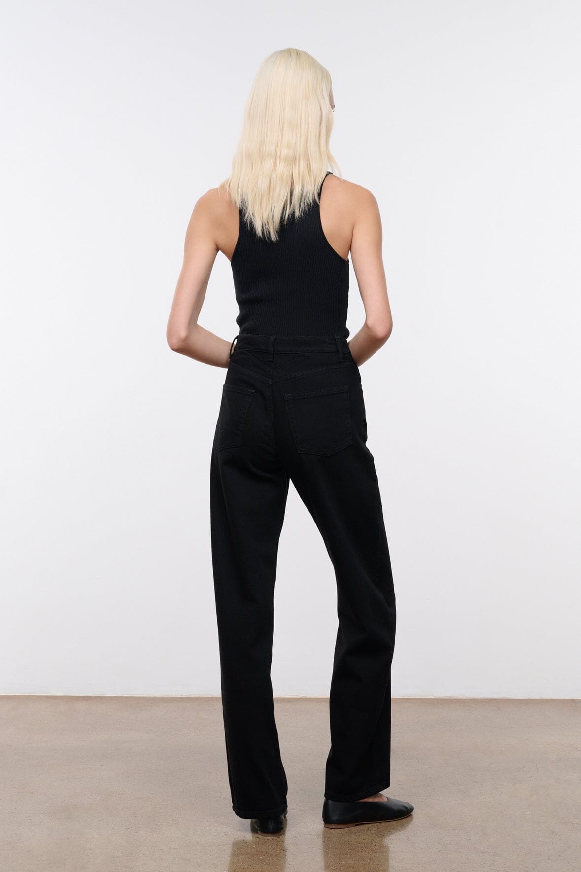 Black high-rise jeans back view with belt loops and center seam