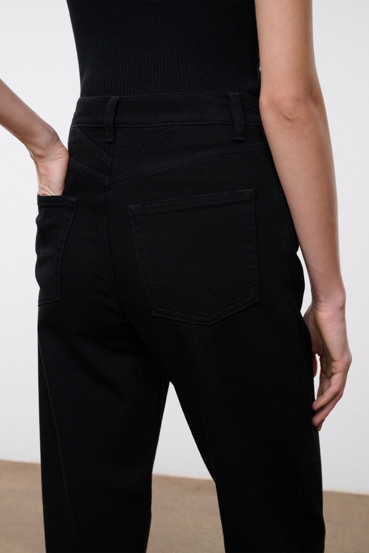Black high-rise jeans front detail with belt loops, patch pockets, zip fly