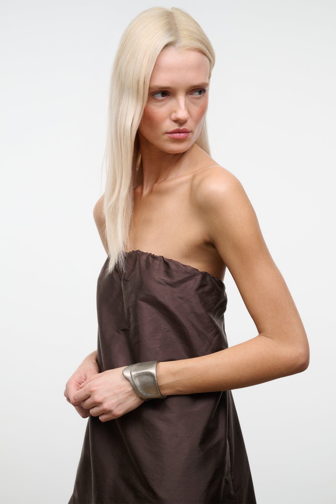 Silver cuff bracelet on wrist, wide metallic band with smooth surface
