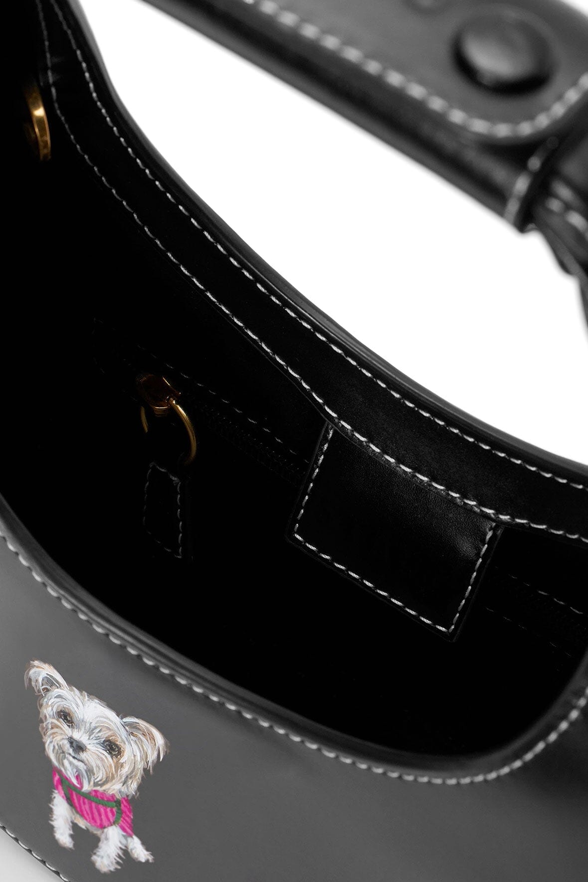 Black mini moon bag front panel with stitched seams and hanging dog charm