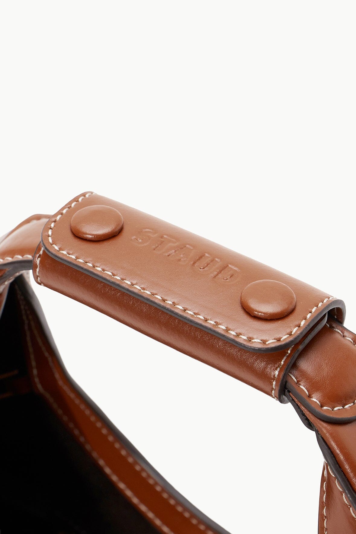 Tan mini moon bag strap end with stitched flap and two snap buttons.