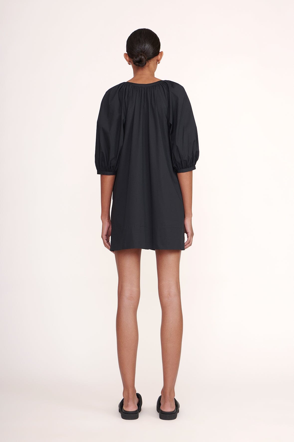 Black mini dress back view with gathered yoke and three-quarter puff sleeves
