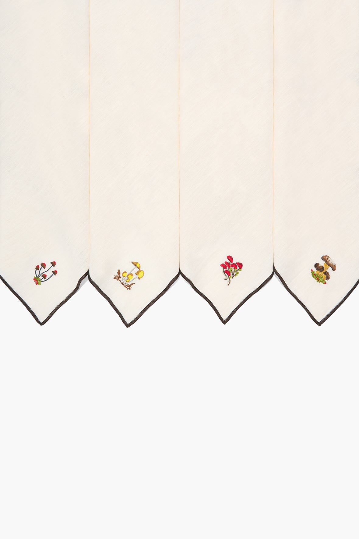 Natural embroidered napkins with black-trimmed edges and colorful corner motifs