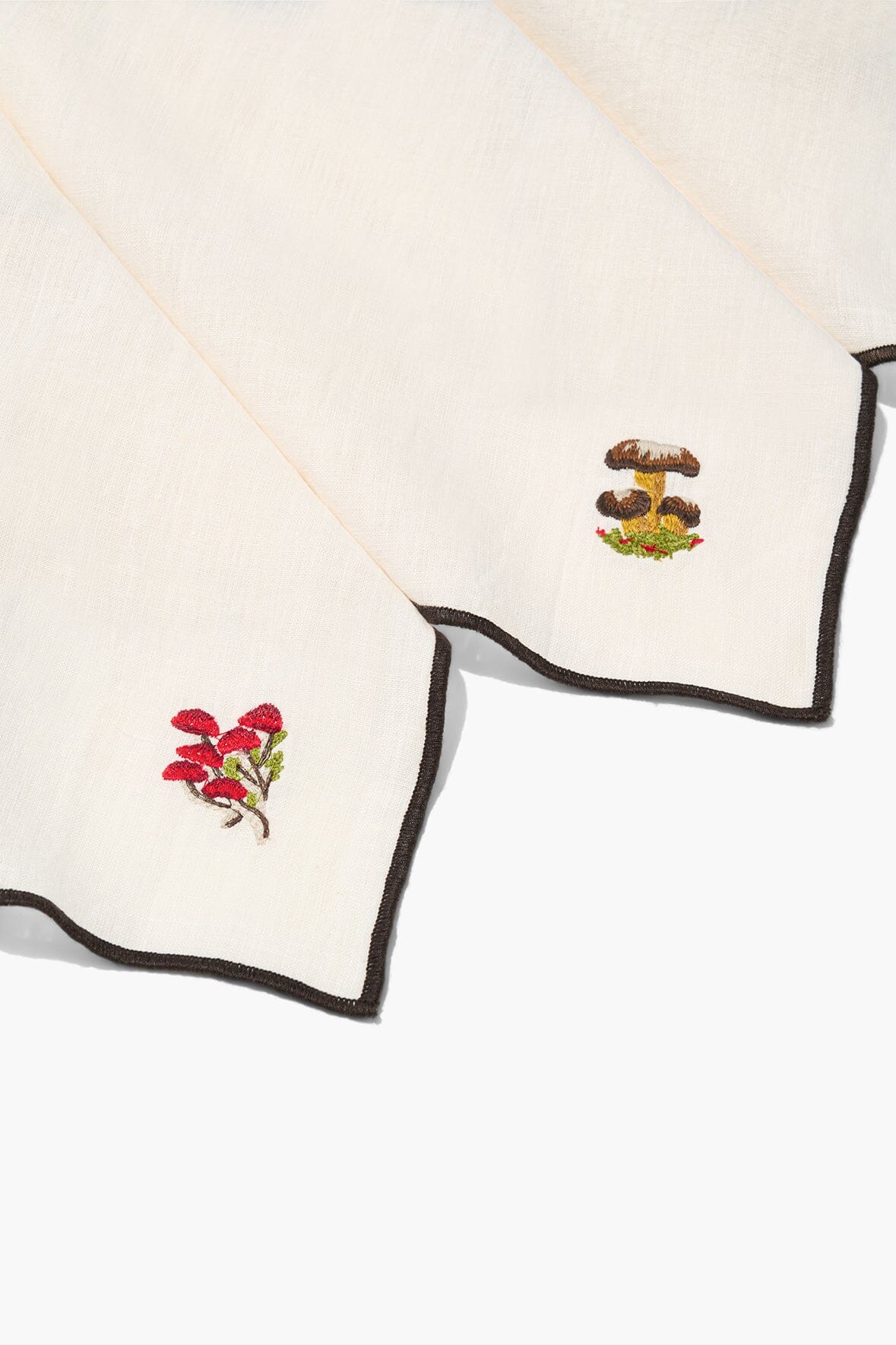 Natural embroidered napkins with black-trimmed edges and red flower corner embroidery