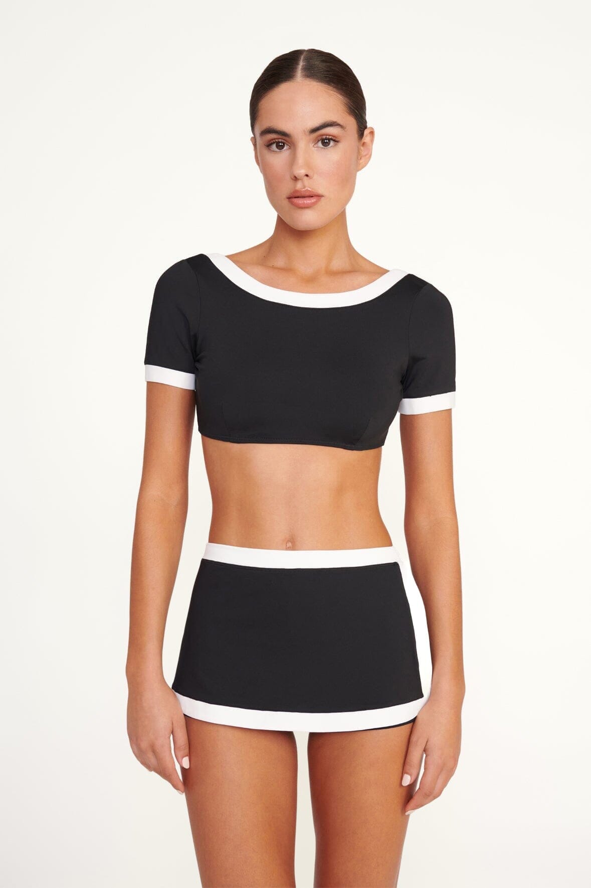 Black swim skirt with white trim at hem and waistband, on model