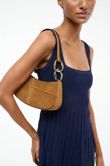 Tan suede hobo bag with curved shape, gold-tone ring pull and stitched panels