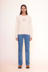 Light pink crewneck sweatshirt with chest graphic, ribbed cuffs and straight hem