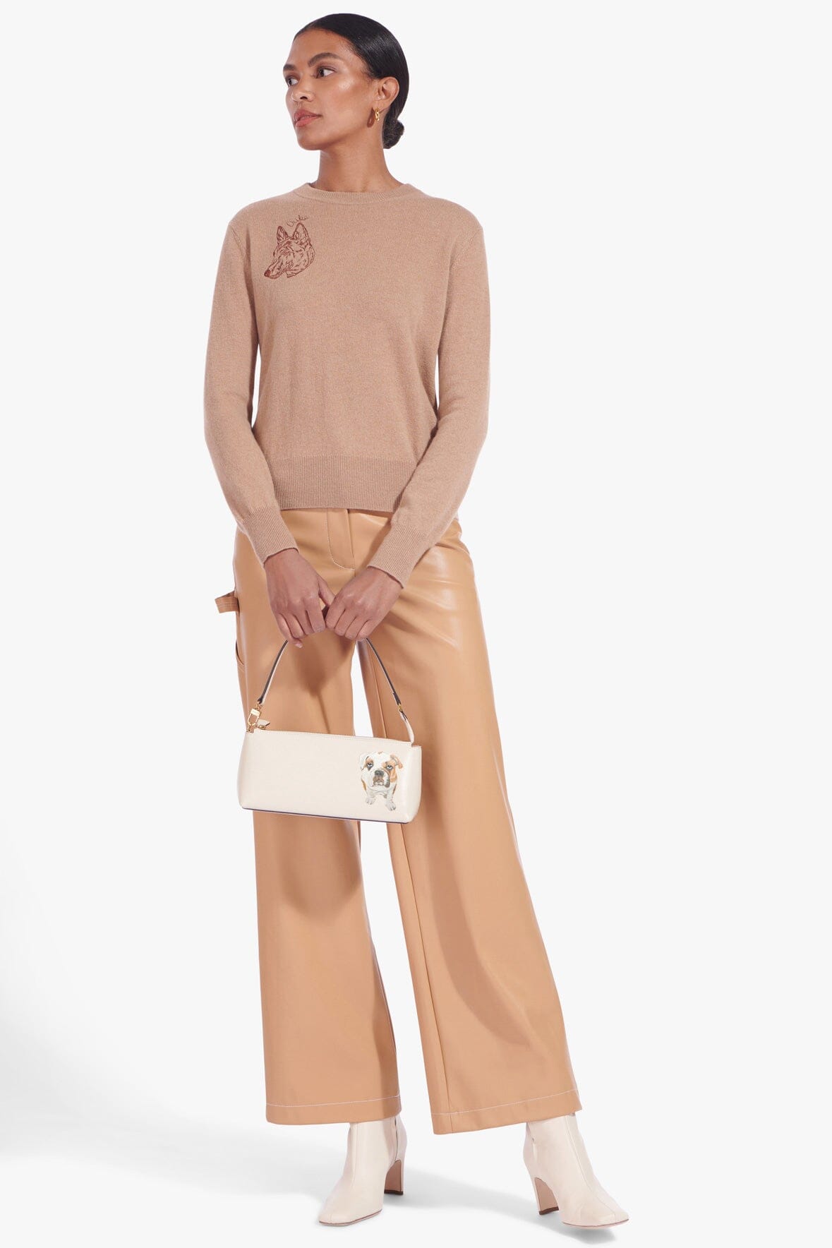 Cream shoulder bag with dog-portrait patch, worn across body by model