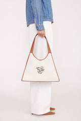 Cream canvas tote bag with tan leather handles and illustrated dog logo