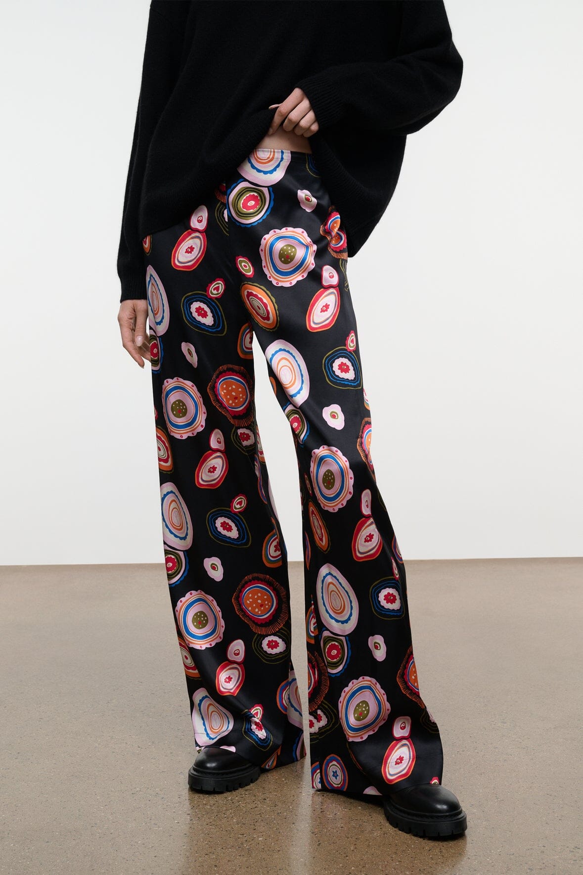 Wide-leg silk pants with bold circular paisley print on black background