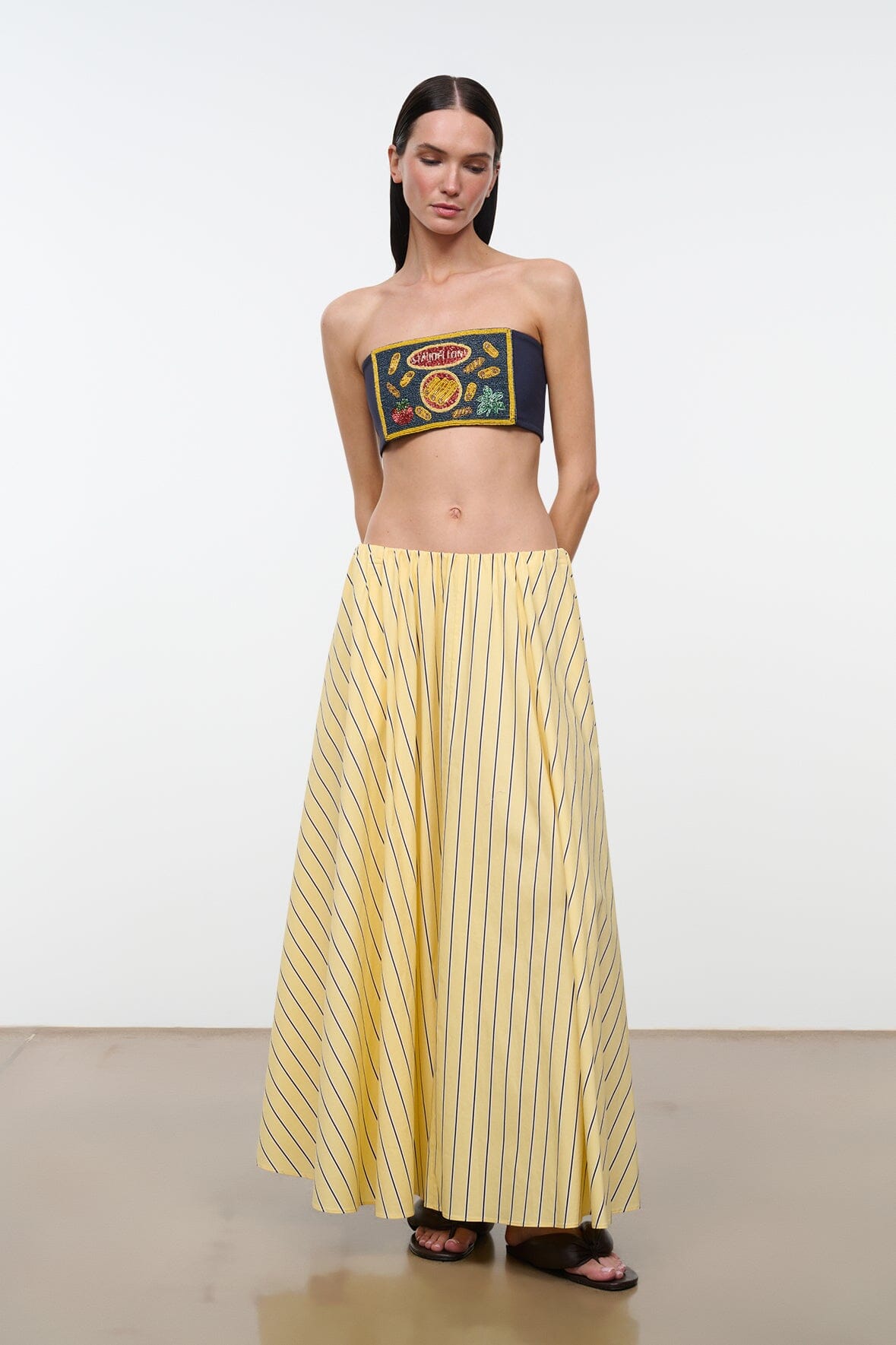 Navy strapless tube top with colorful embroidered logo patch and yellow trim