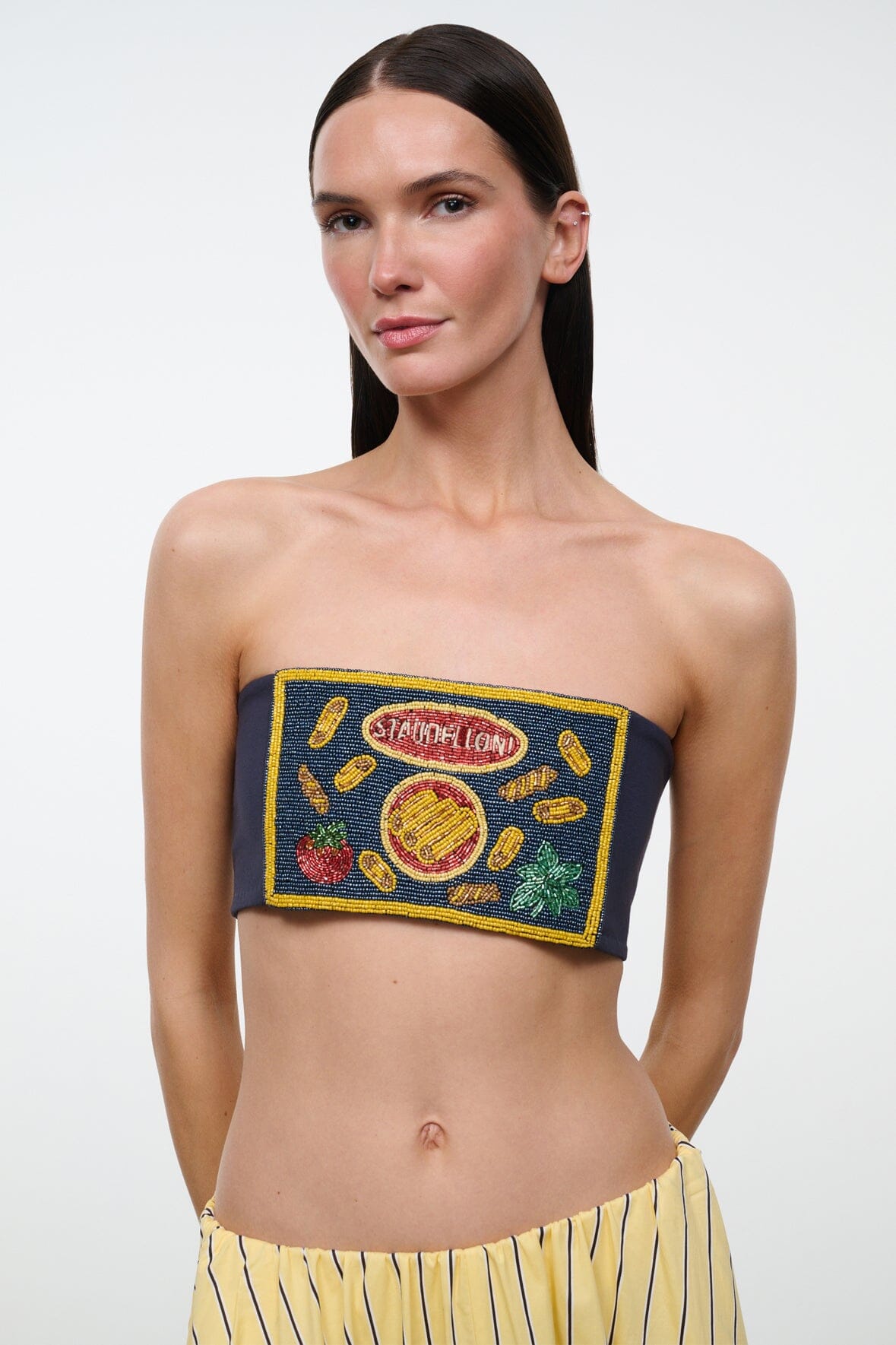 Front close-up of navy strapless tube top with colorful embroidered patch and yellow trim