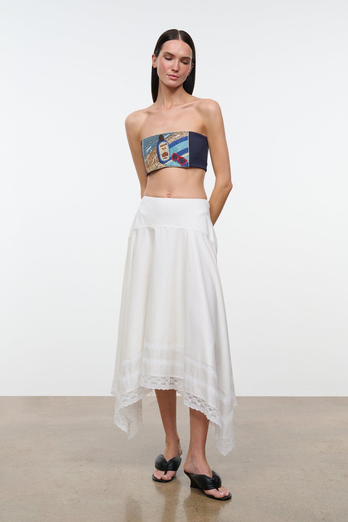 Strapless tube top with multicolor graphic print, paired with white tiered skirt
