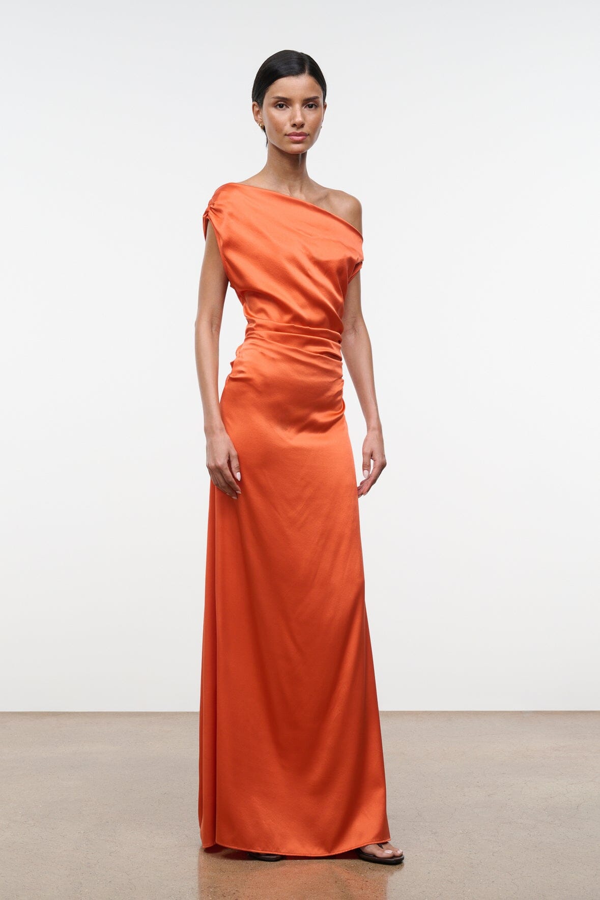 Orange silk maxi dress with one-shoulder drape and gathered waist