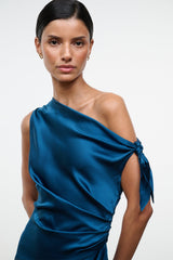 Teal-blue one-shoulder silk dress close-up with draped shoulder knot and ruched waist