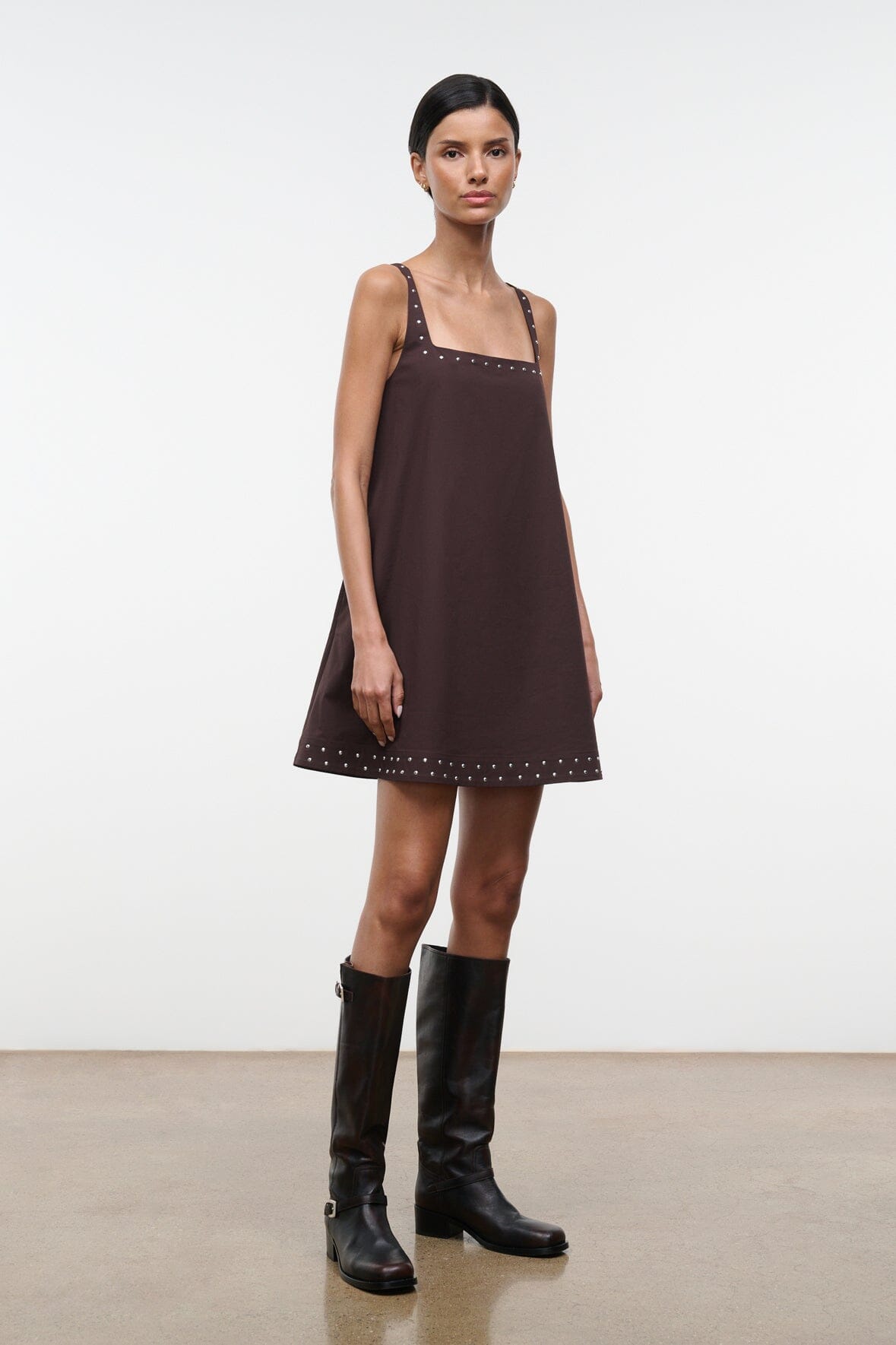 Dark brown sleeveless shift dress with studded square neckline and hem, shown at angle