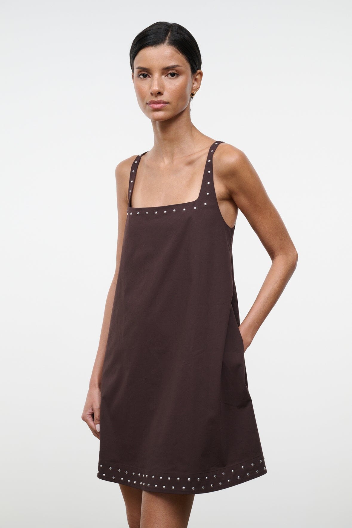 Dark brown sleeveless shift dress with square neckline and studded trim around the hem