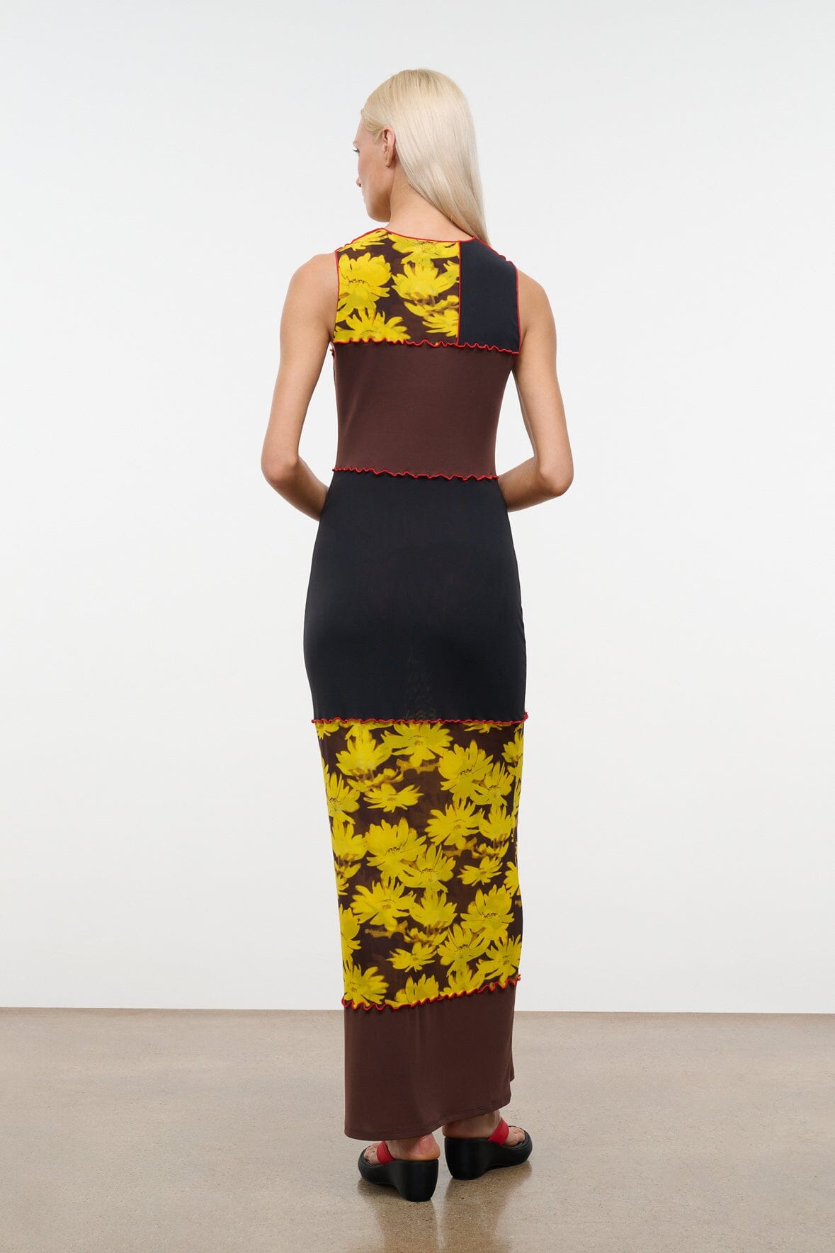 PRIMO sleeveless dress back view, black bodice with brown panel and yellow daisy hem