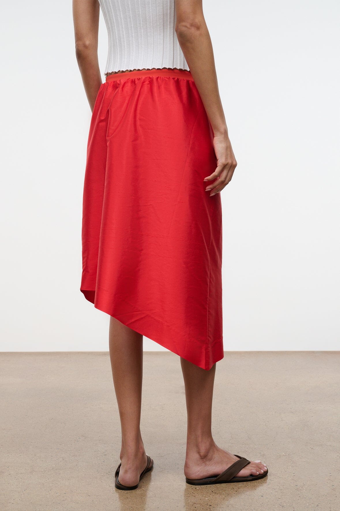 Convertible silk dupioni top detail, red asymmetrical skirt-like hem with visible seam