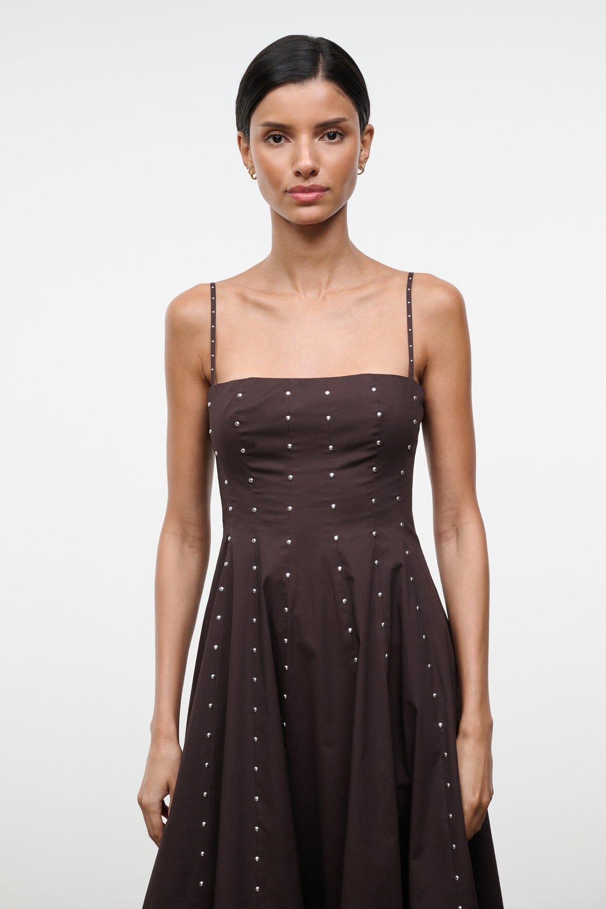 Wylie dress front close-up: dark strap bodice with small stud dots