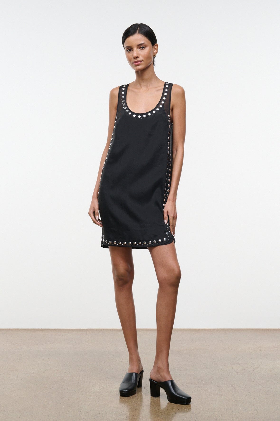 Black sleeveless mini dress with stud-trim detail at neckline and hem