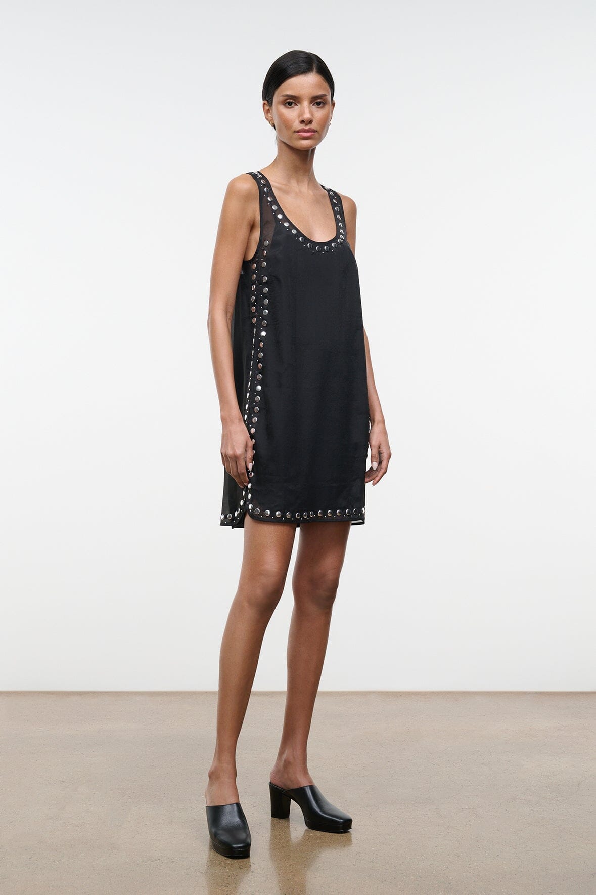 Black sleeveless mini dress with stud embellishments along neckline and hem
