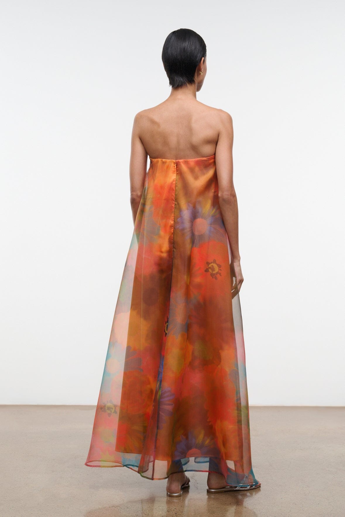 Back view of strapless maxi dress with abstract orange and teal floral print