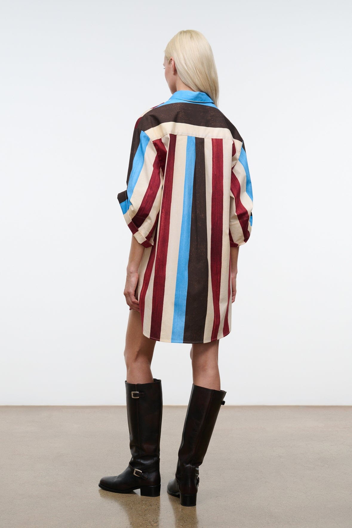 Back view shirt dress with vertical brown, cream, red & blue stripes and collared neck