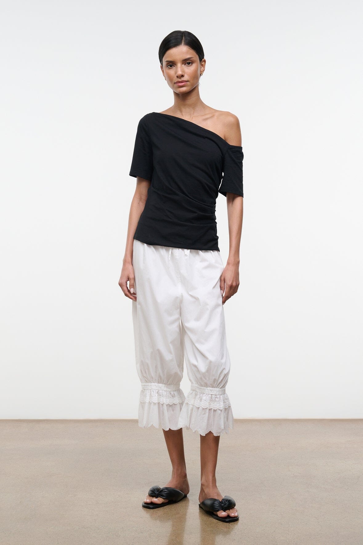 Black Carine top with diagonal one-shoulder neckline and short sleeves, side view