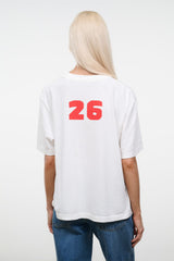 Back view of white relaxed tee with large red “26” print across the upper back.