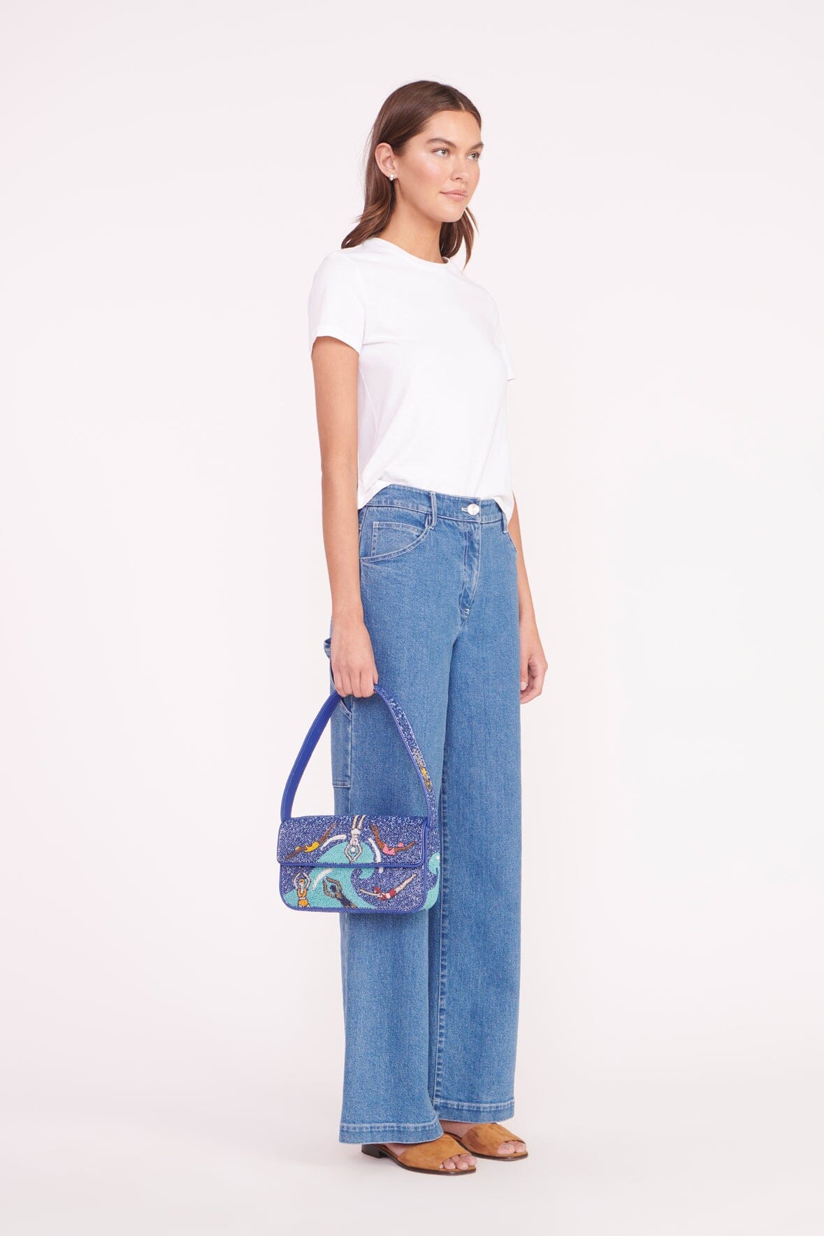 Beaded mini bag worn crossbody-style, blue swimmers print on model with jeans