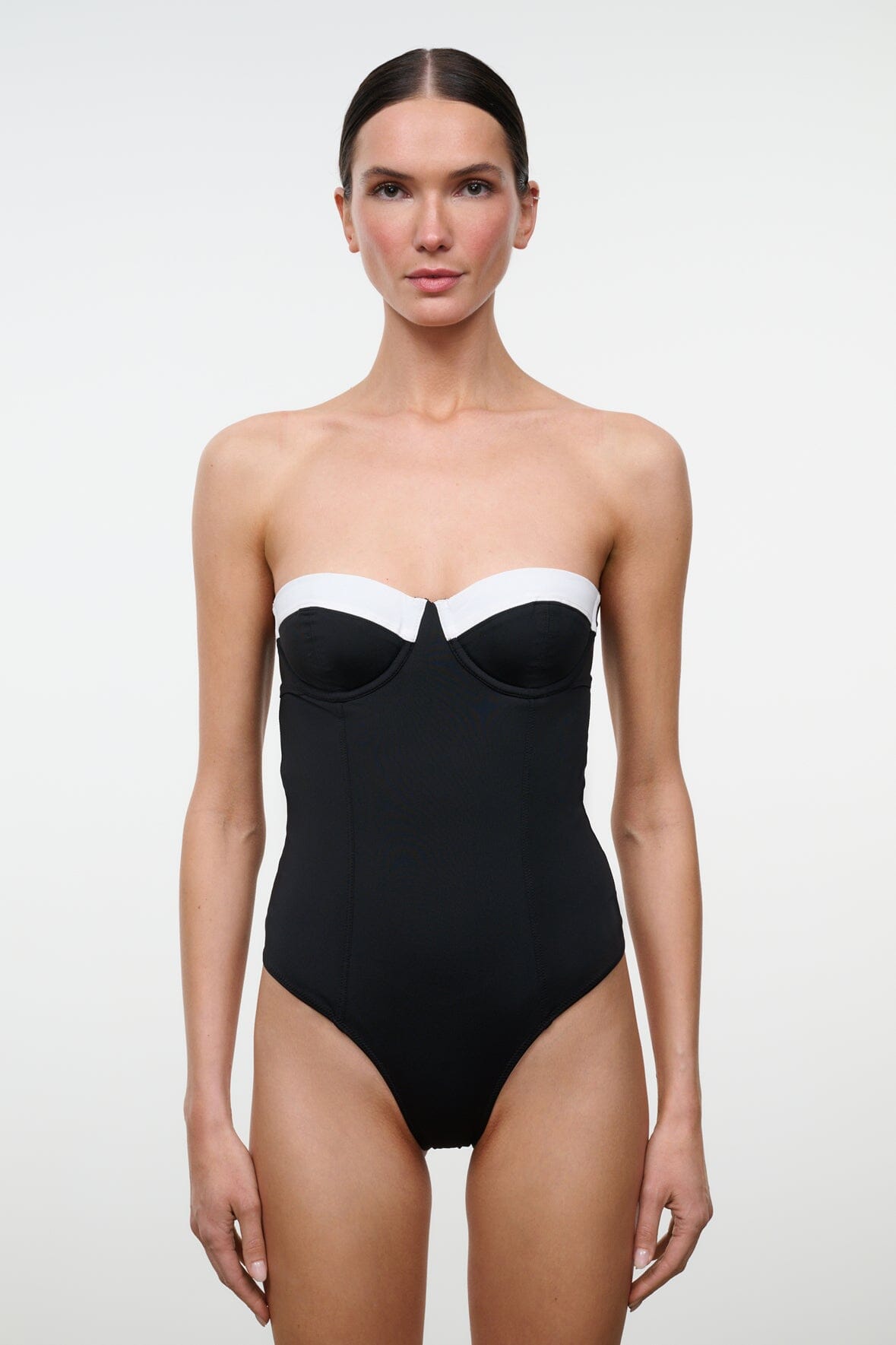 Black one-piece swimsuit with white sweetheart bust panel, front view close-up