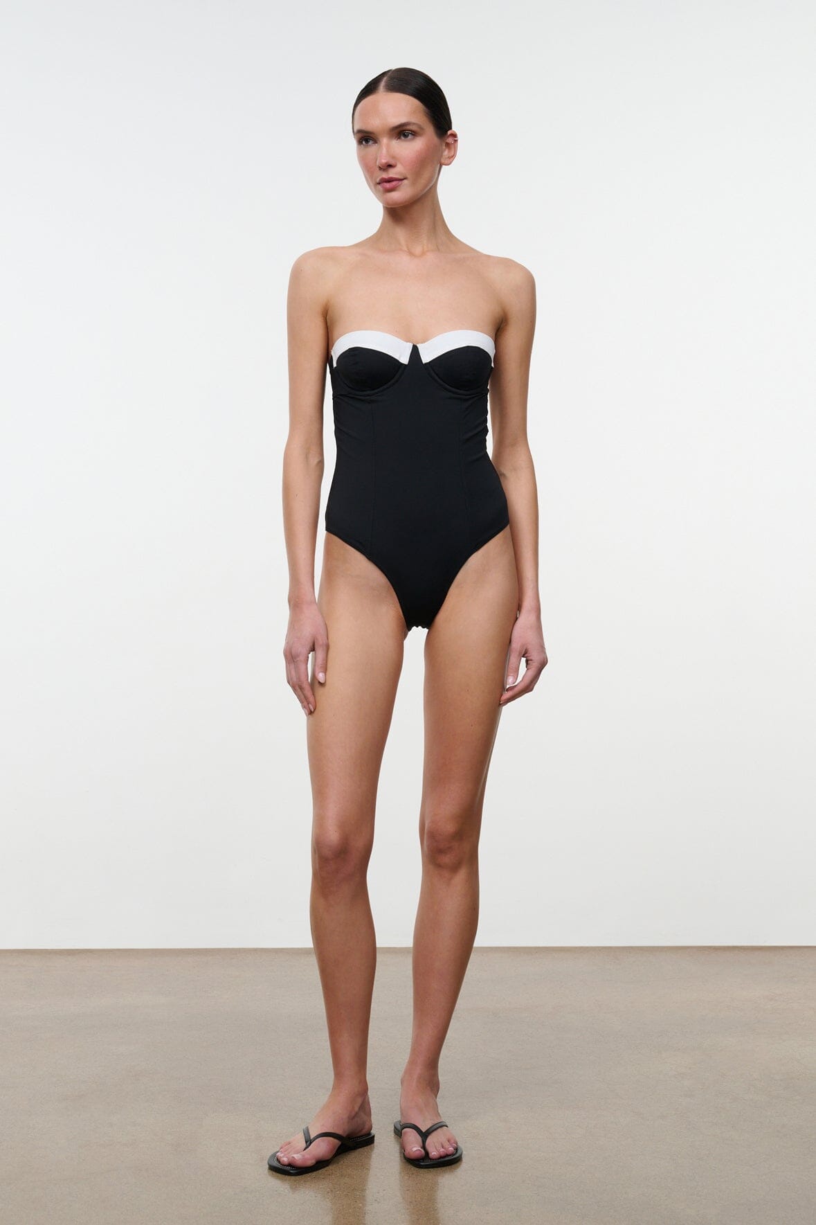 Black one-piece swimsuit with white sweetheart bust panel and thin straps, full front view