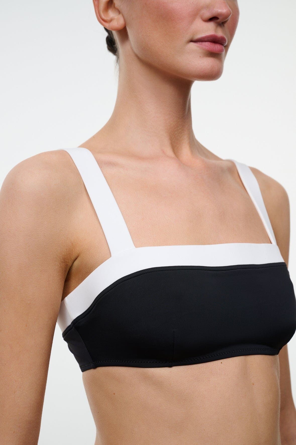 Black and white bikini top with square neckline, thin straps, and white trim