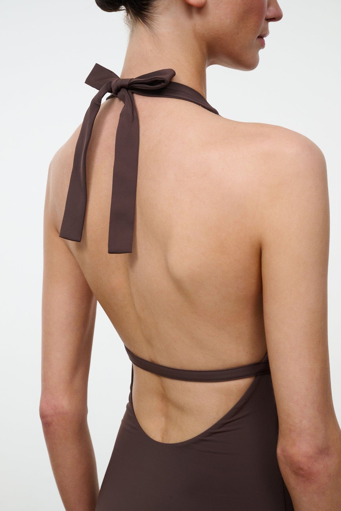 Dark brown one-piece swimsuit back with narrow cross straps and neck bow tie