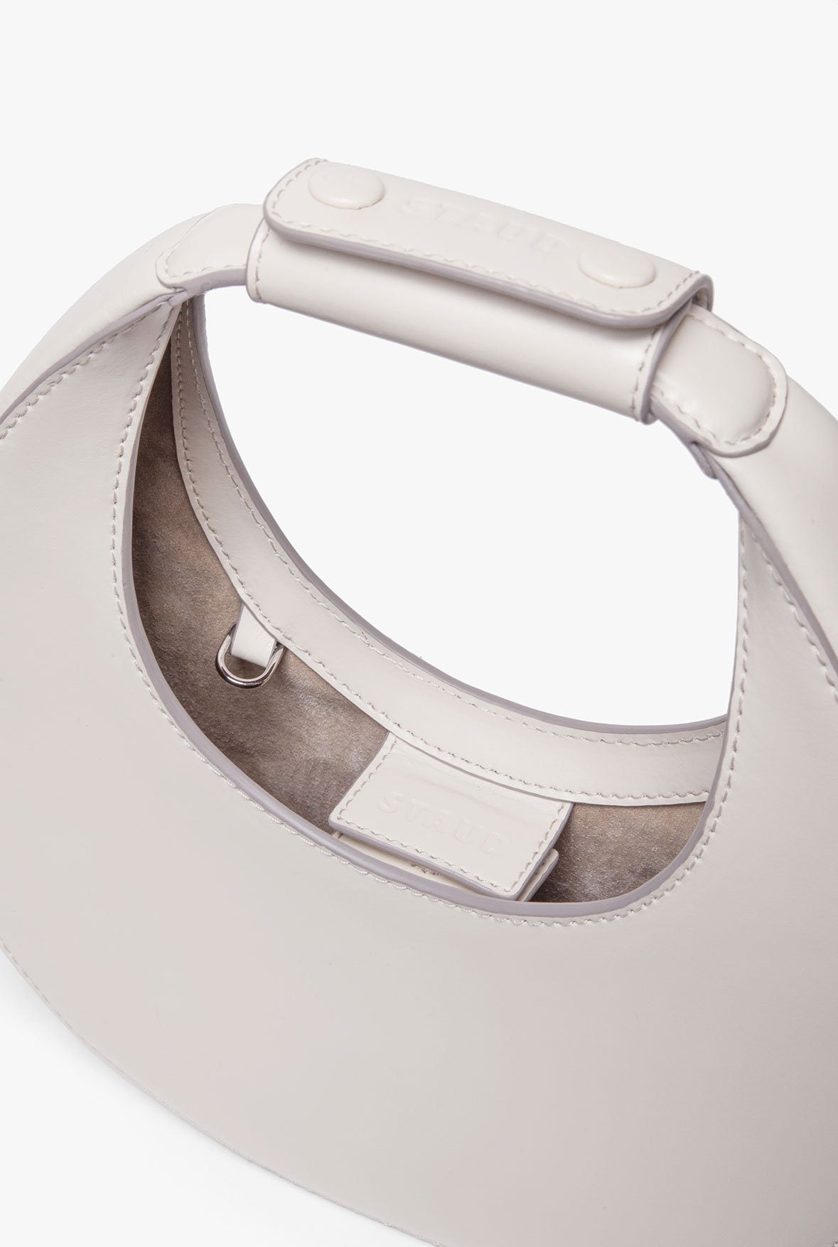 Cream mini moon bag interior with adjustable strap and buckle detail