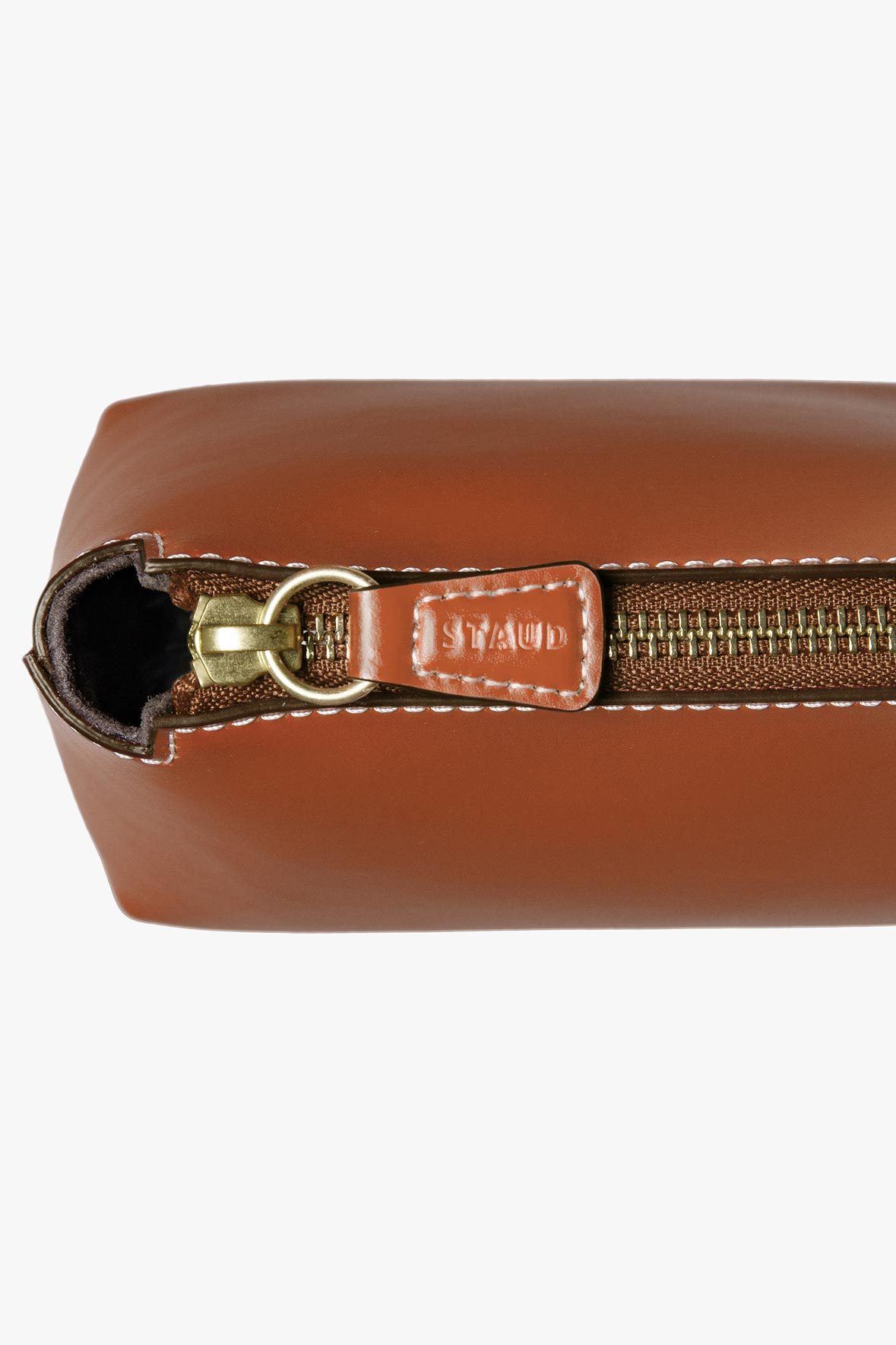 Saddle brown mini leather bag interior with brass clasp and brand patch