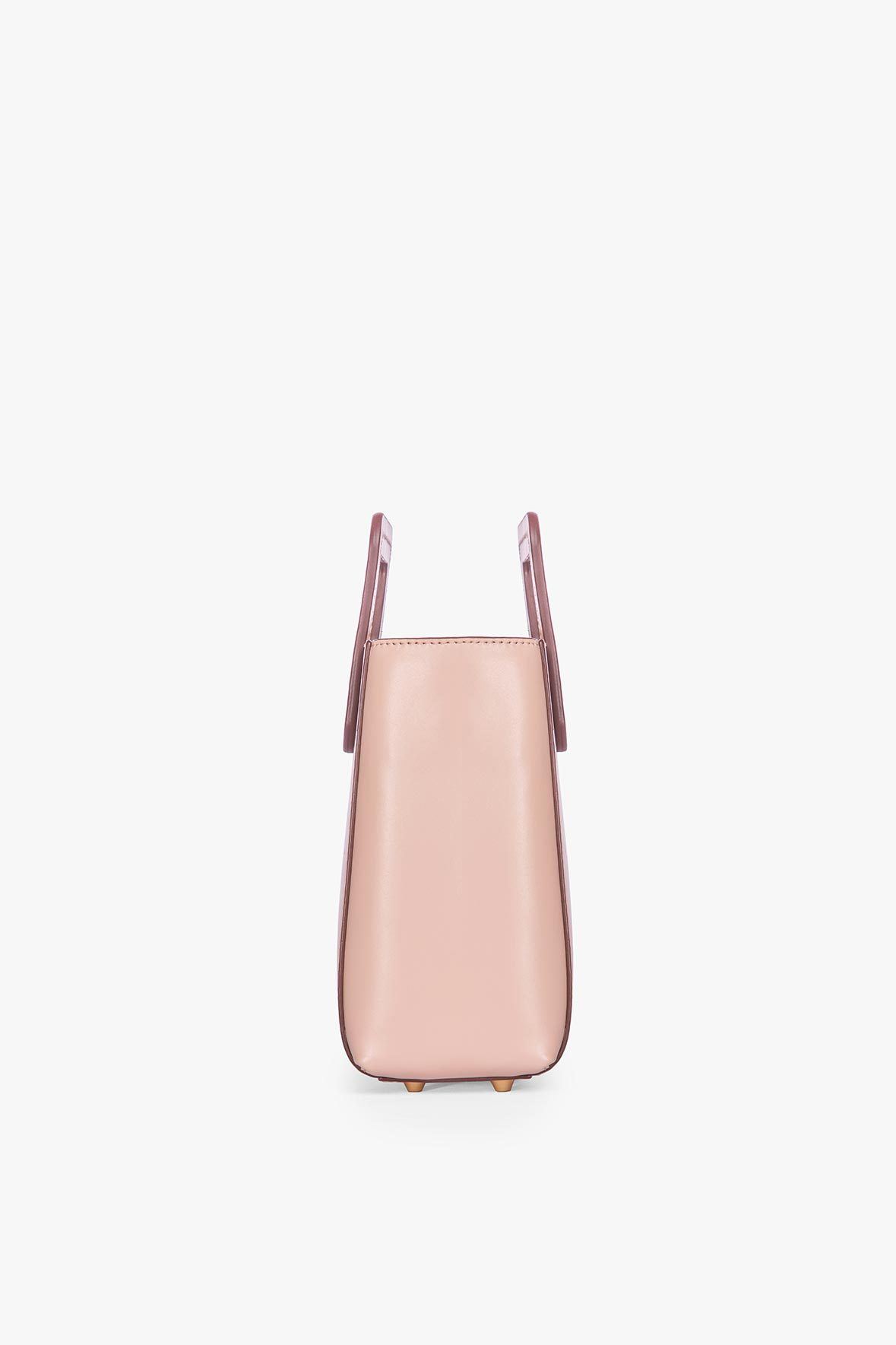 Blush leather mini tote bag with two top handles and slim side profile