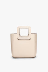 Mini cream leather bag with top handle and square cutout detail on front