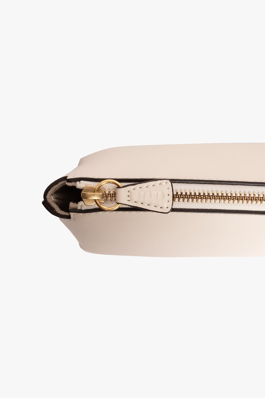 Cream leather mini bag detail with gold zipper and small tab hardware