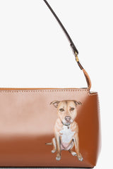 Tan zipper shoulder bag with pictured dog on front and adjustable leather strap