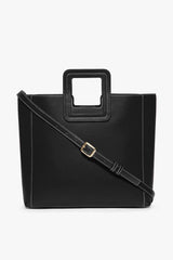 Black leather tote bag with adjustable crossbody strap and metal buckle
