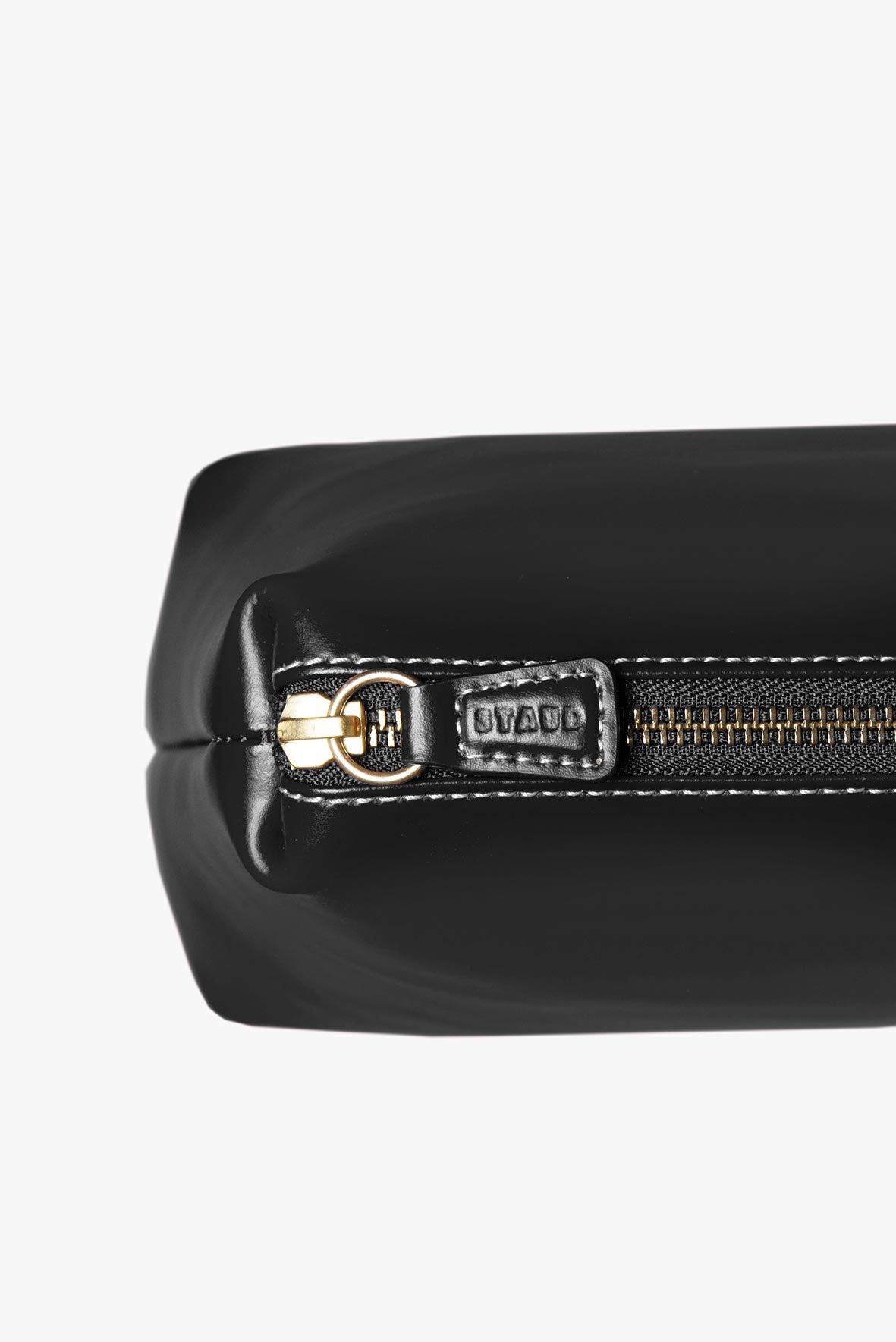 Black leather bag with gold-toned zipper pull and metal zipper slider