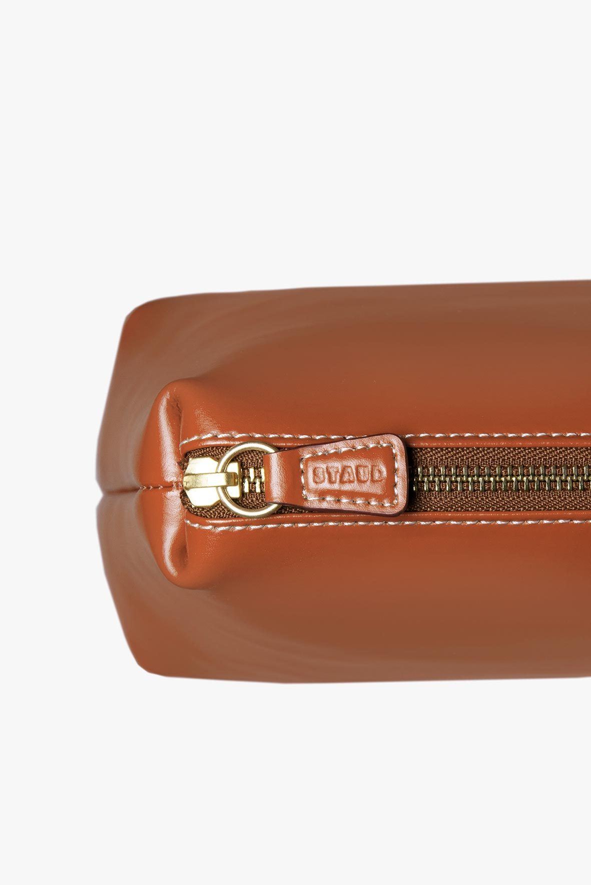 Tan leather bag close-up of zipper pull and brand label tab