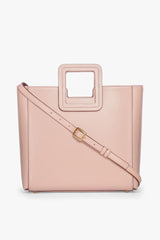 Blush leather tote bag with crossbody strap and gold buckle hardware