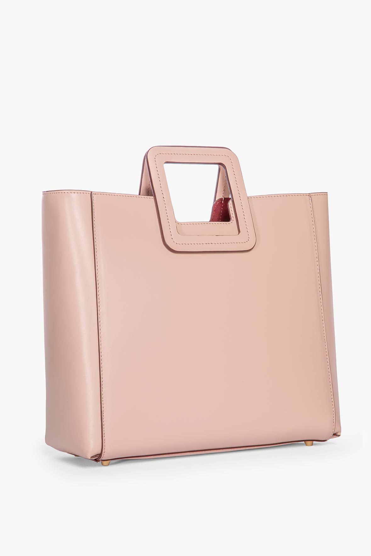 Blush leather tote bag front view with top handle cutout panel
