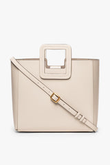 Cream leather tote with top handle and diagonal crossbody strap