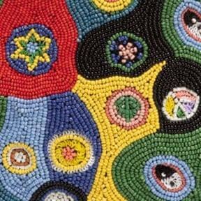 Close-up of beaded millefiori patchwork in red, green, blue, and yellow motifs
