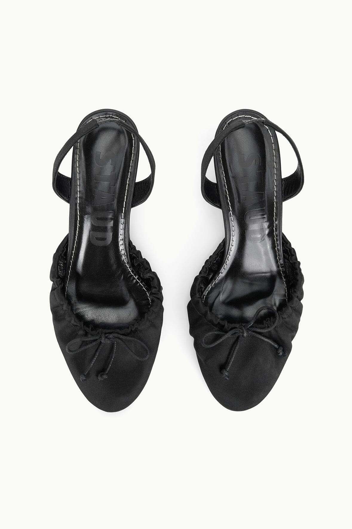 Black satin slingback ballet shoes, back view with bow and adjustable sling strap