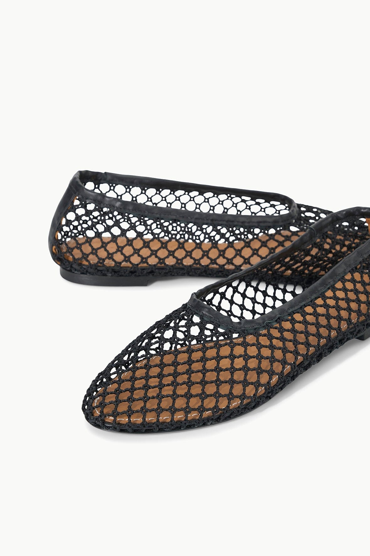 Black netting ballet flat with round toe and flat black sole.